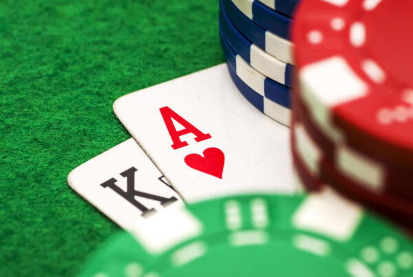 Ace and king of hearts cards with casino chips on green felt