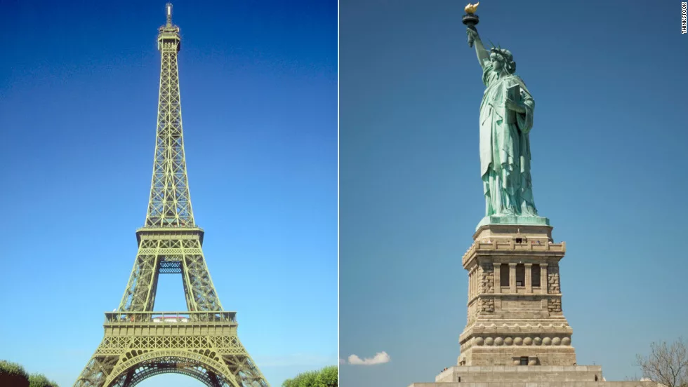 Eiffel Tower in Paris and Statue of Liberty in New York side by side under blue sky
