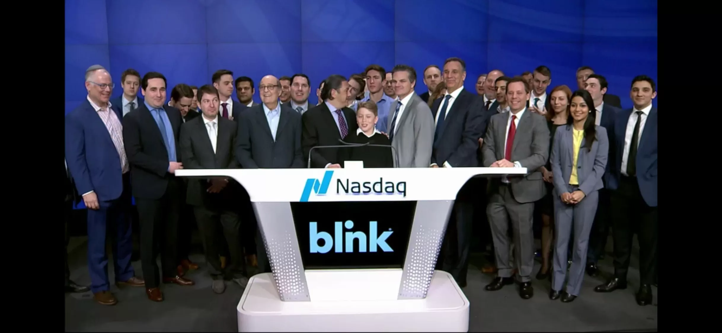 Group of professionals at Nasdaq with Blink logo on podium.