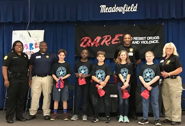 Officers with students at DARE program graduation event