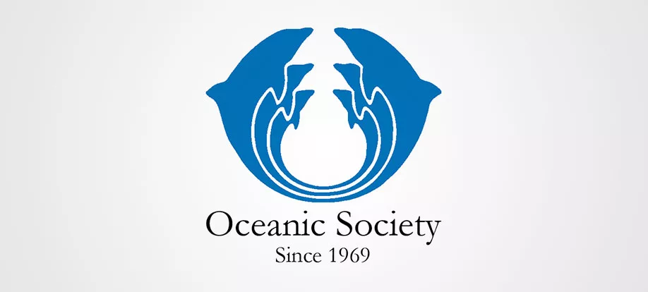 Blue logo of Oceanic Society with dolphin silhouette over a globe design