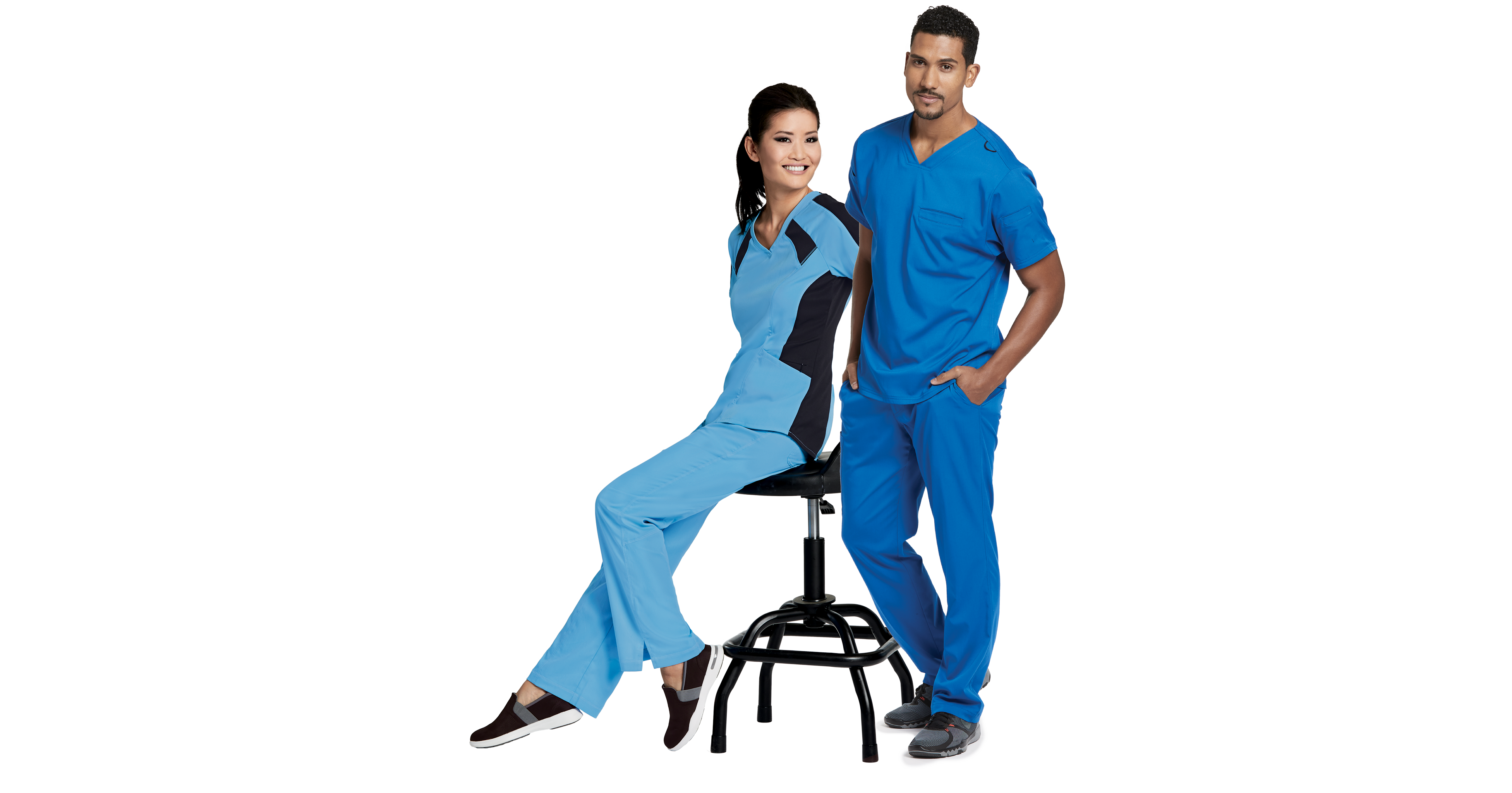 Two healthcare professionals in blue scrubs smiling against white background