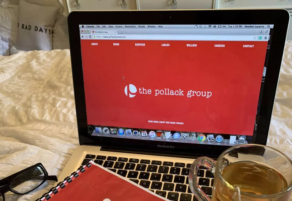 Laptop on bed displaying The Pollack Group website