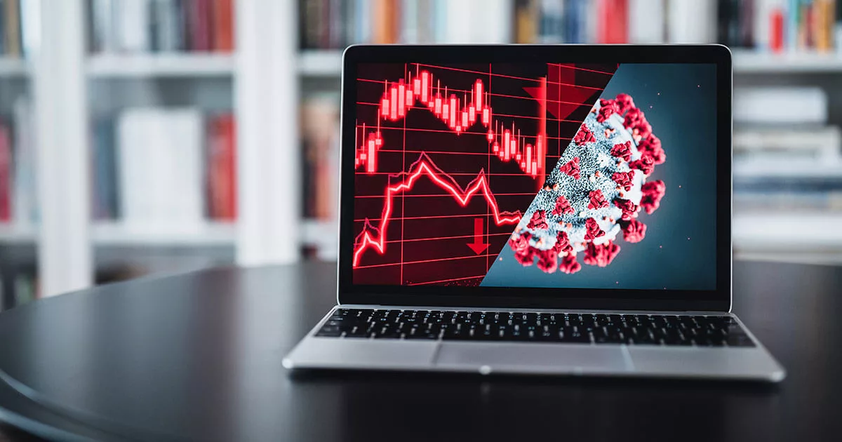 Laptop with stock market crash graph and virus structure on screen