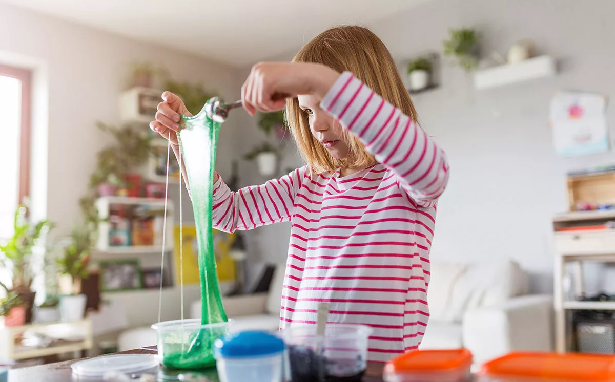 Girl performing a fun science experiment with homemade slime at home