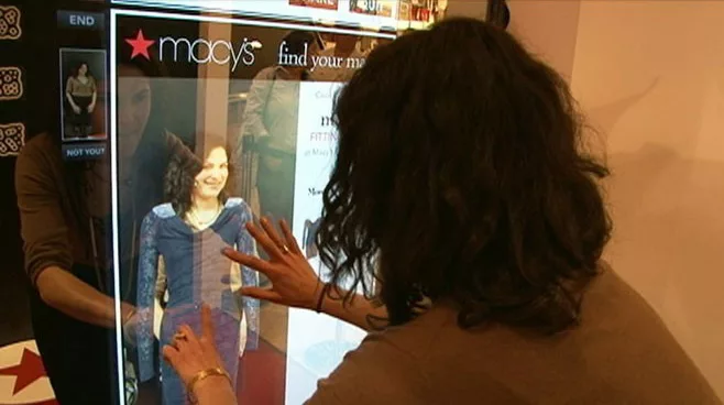 Person using Macy's digital fitting room mirror technology.