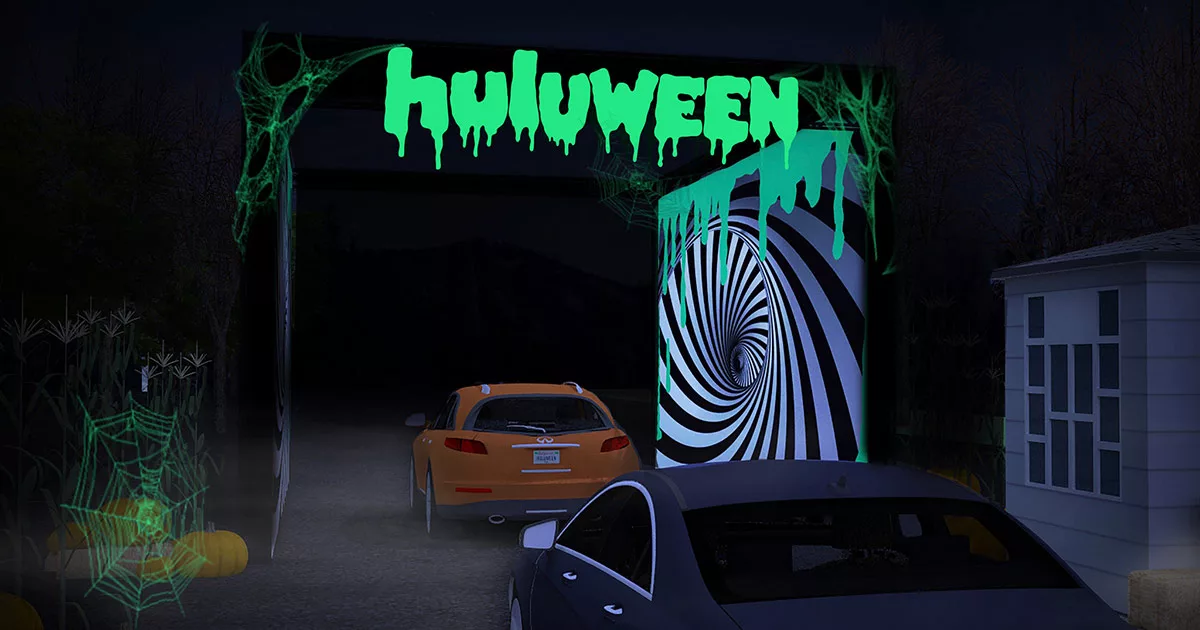 Halloween-themed drive-through with spooky decorations and cars.
