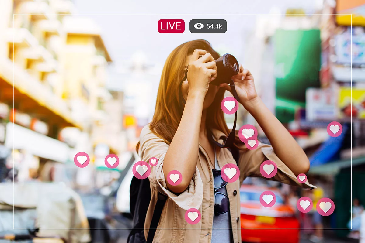 Woman taking photos with camera on city street with live stream hearts and viewer count.