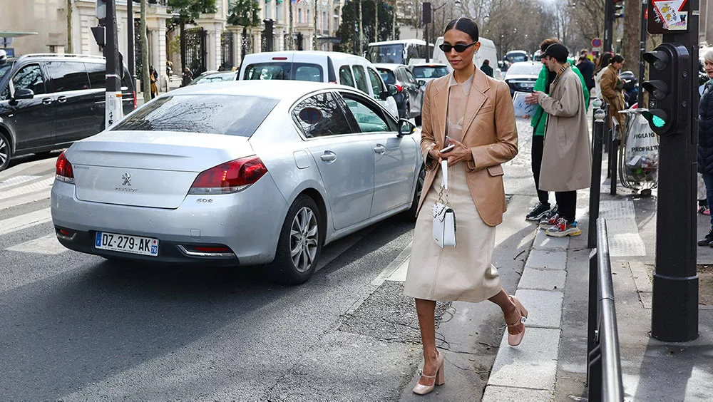 Stylish woman in chic outfit on city street with cars and pedestrians