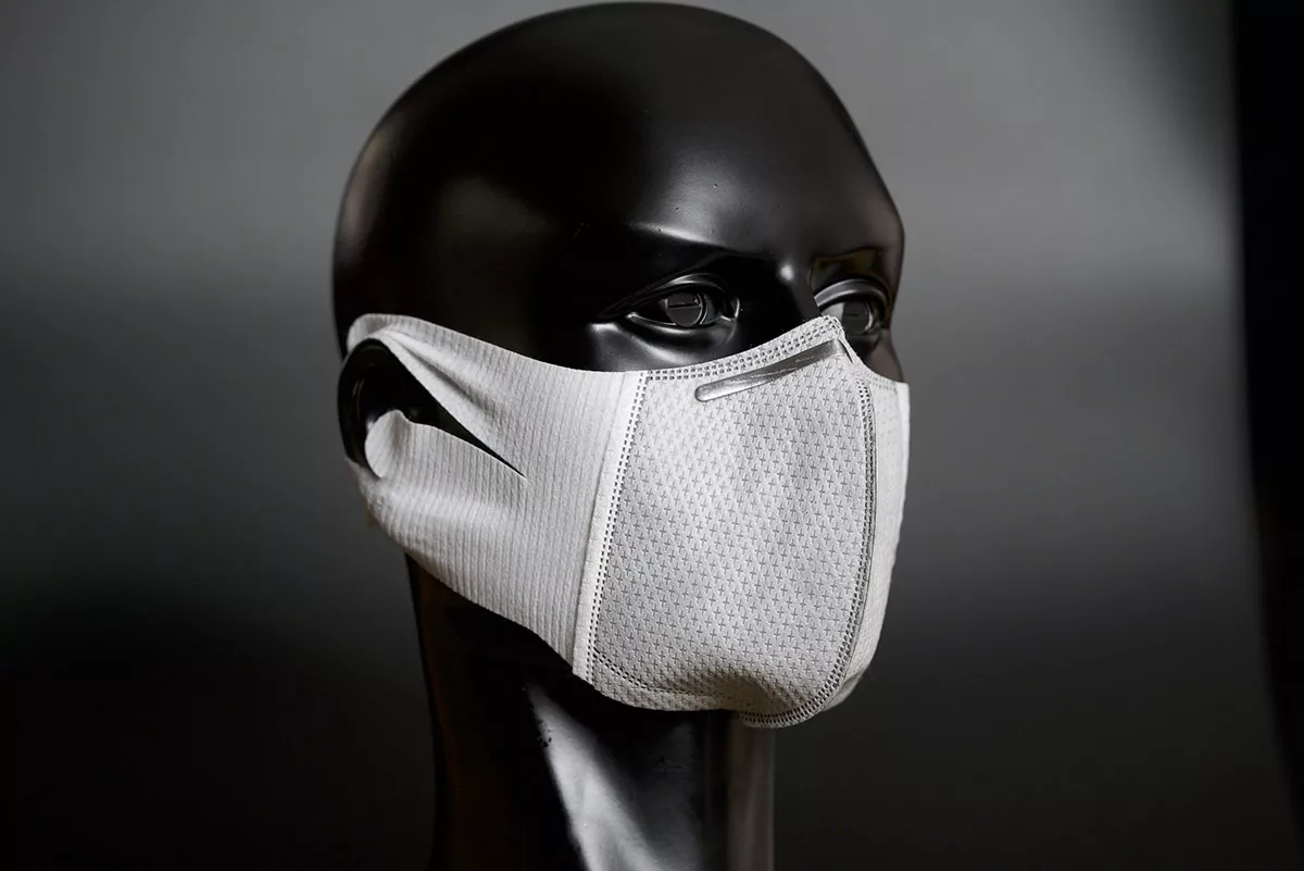 Mannequin head with white fabric face mask against gray background
