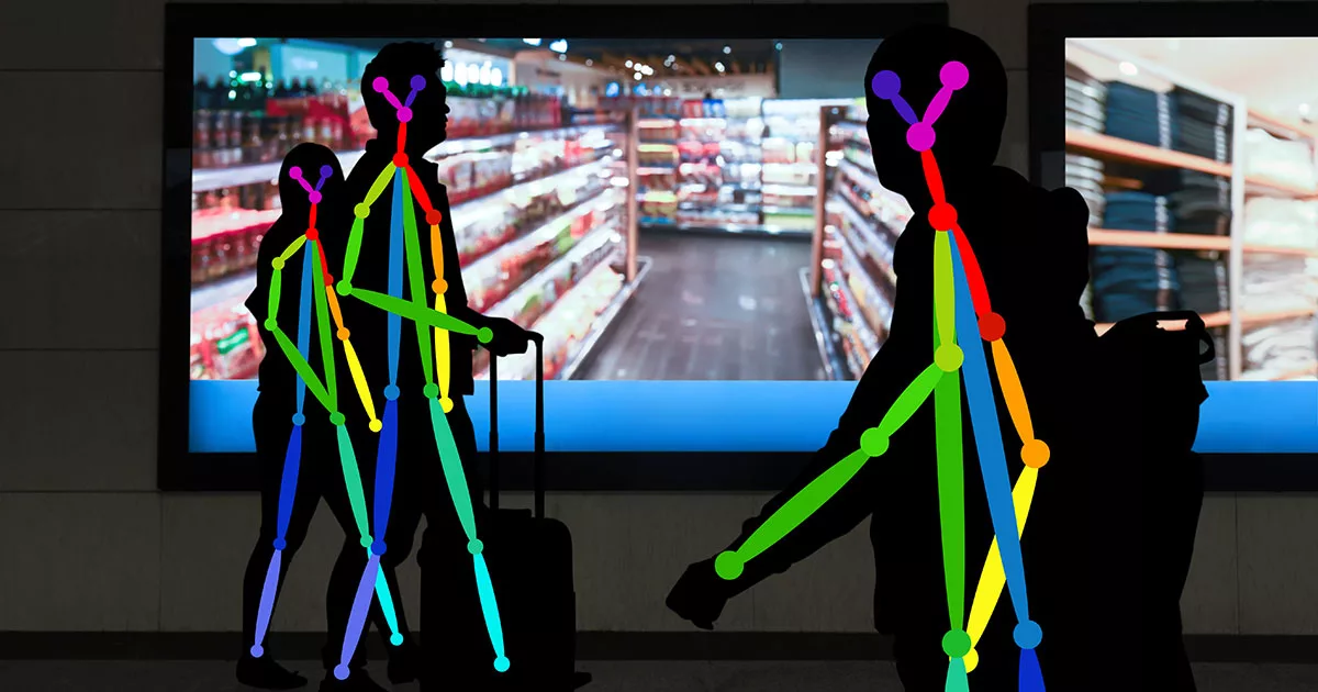 Silhouetted figures with colorful digital joints in front of grocery store screen