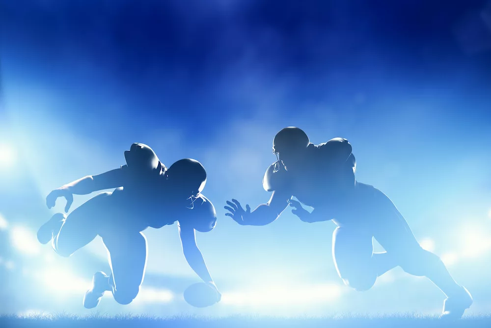 Silhouettes of football players in action on a vibrant blue background