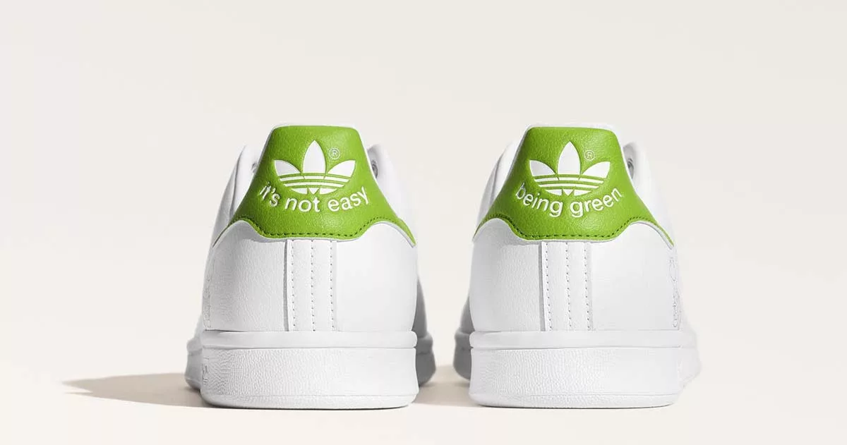 White sneakers with green logo and text "It's not easy being green" on heels.