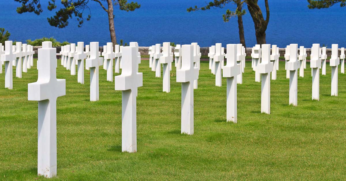 White crosses in military cemetery with ocean backdrop