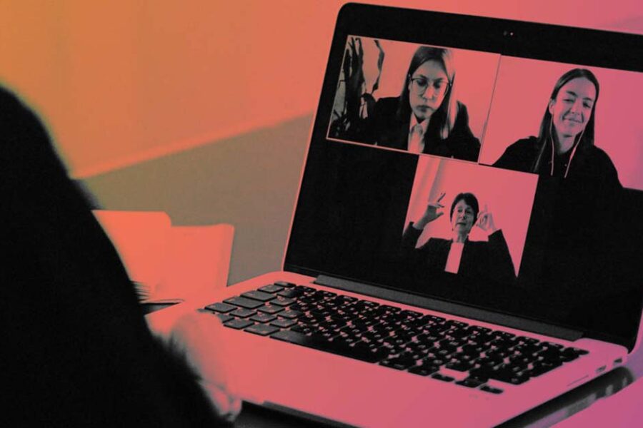 Laptop displaying video conference with four participants