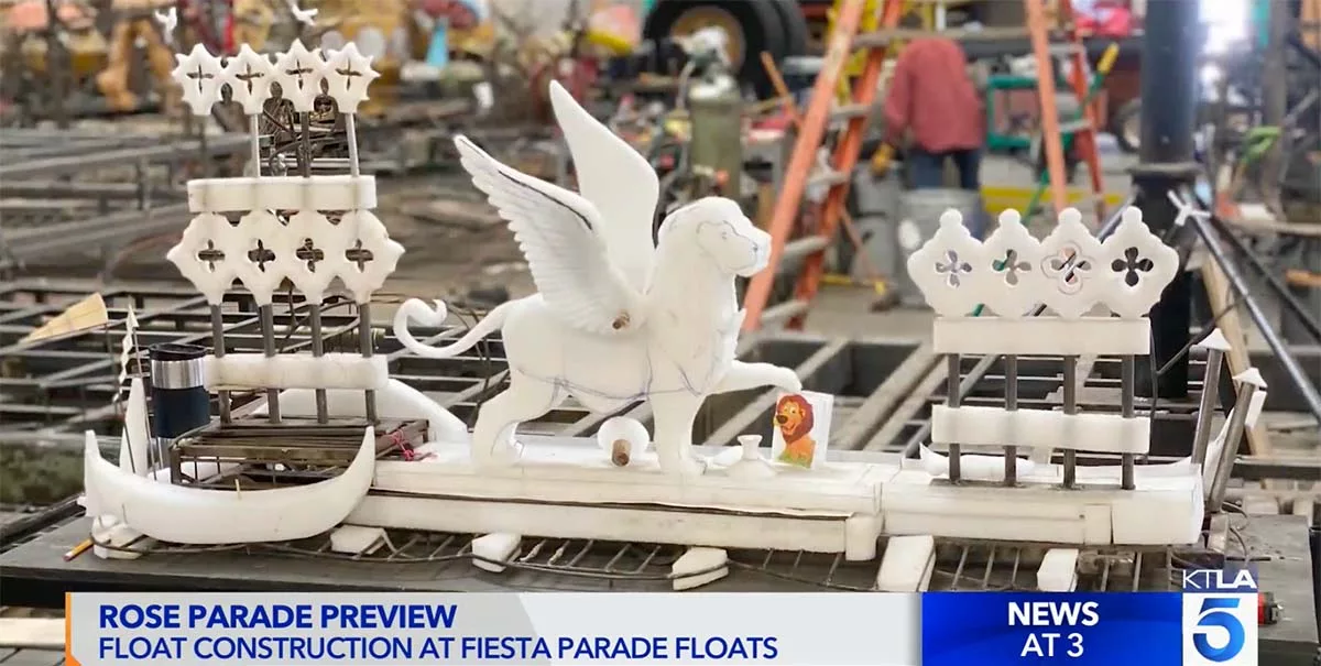 Miniature parade float with white Pegasus and ship under construction