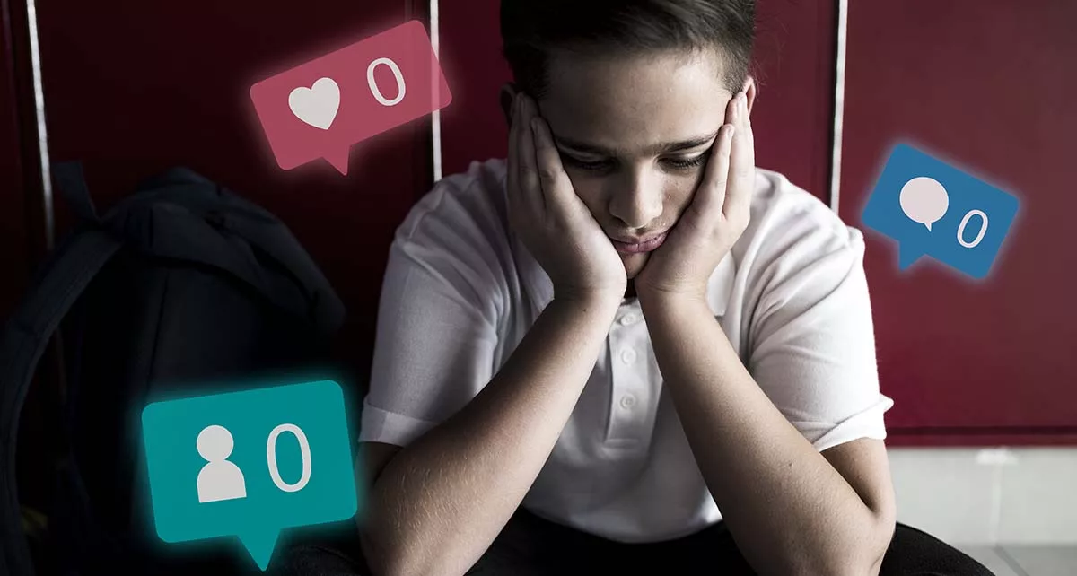 Disheartened teen with zero social media notifications sitting in school hallway