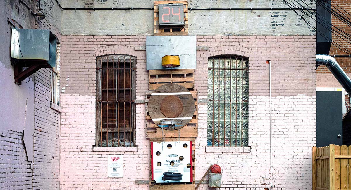 Urban brick wall with eclectic objects and basketball hoop