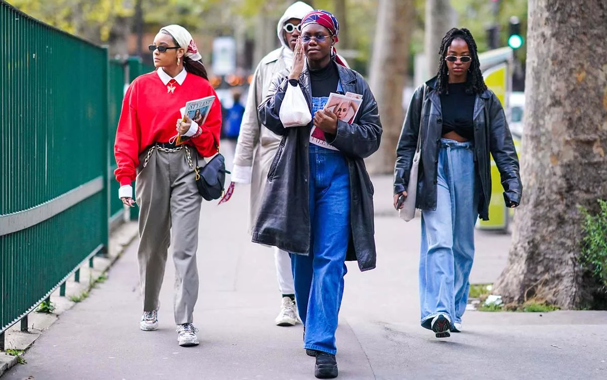 Three people walking in stylish streetwear fashion during daytime