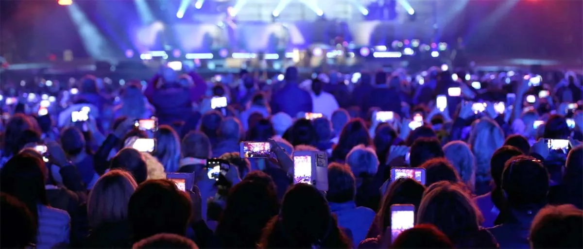 Crowd at concert capturing event on smartphones with stage lights