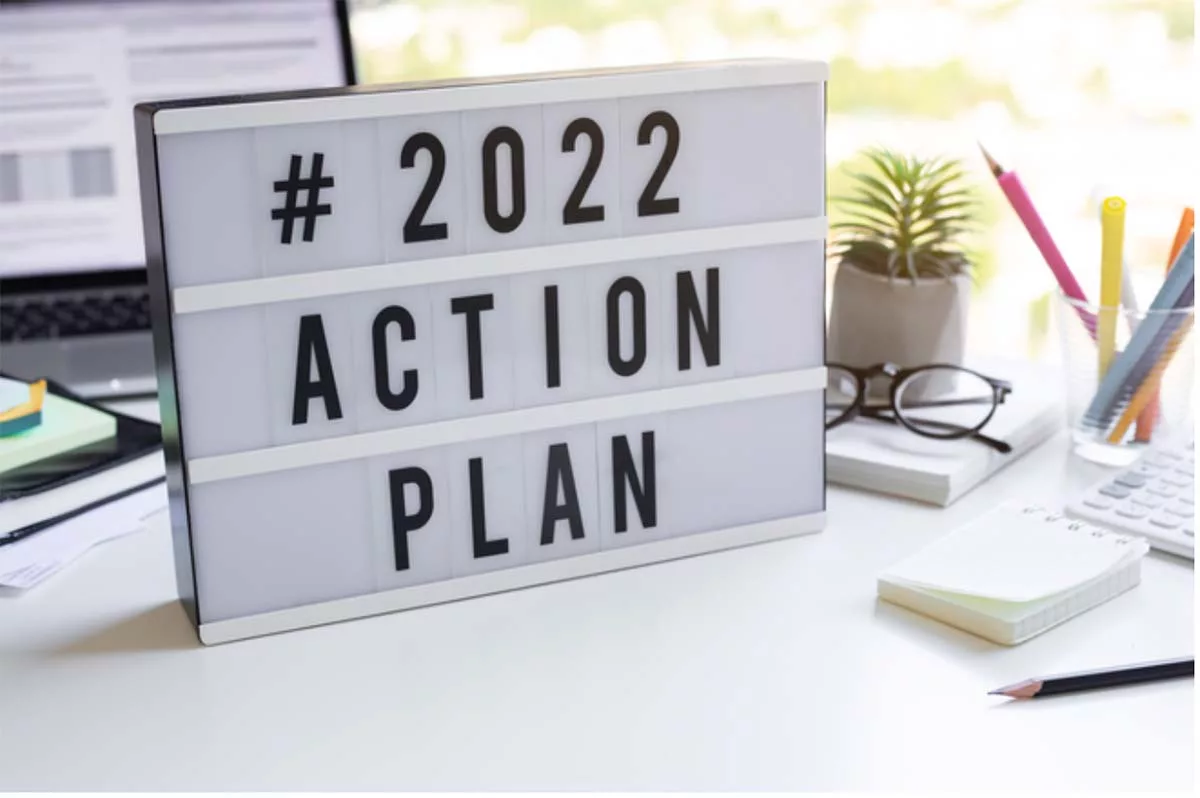 2022 action plan sign on a desk with office supplies and computer