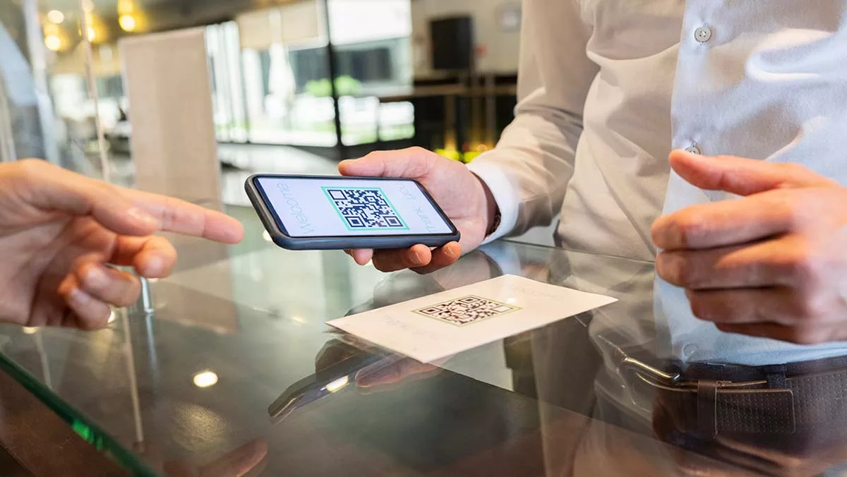 Person scanning QR code with smartphone at restaurant for contactless menu