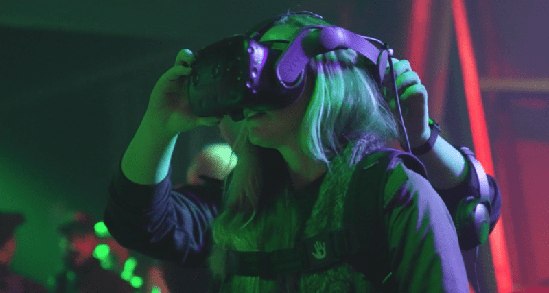 Woman experiencing virtual reality headset at an event with neon lighting