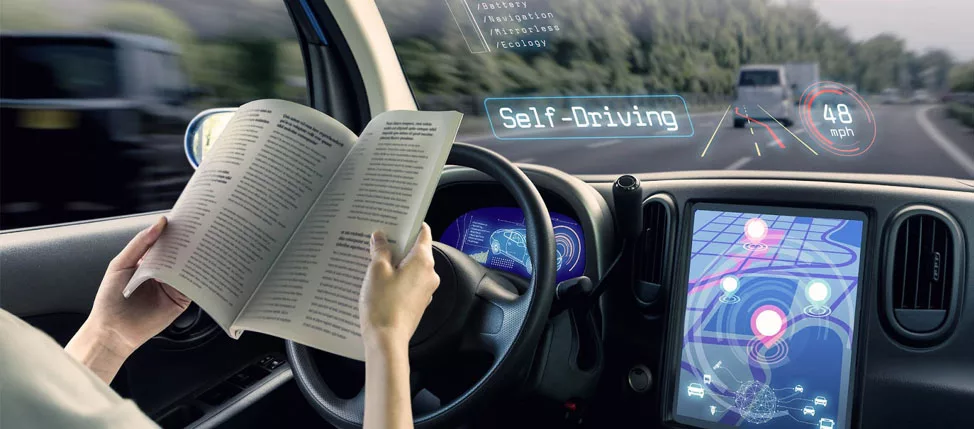 Person reading book in self-driving car with heads-up display and navigation screen