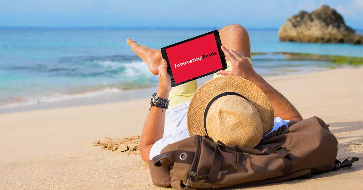 Person relaxing on beach with tablet reading "Interesting Reads"