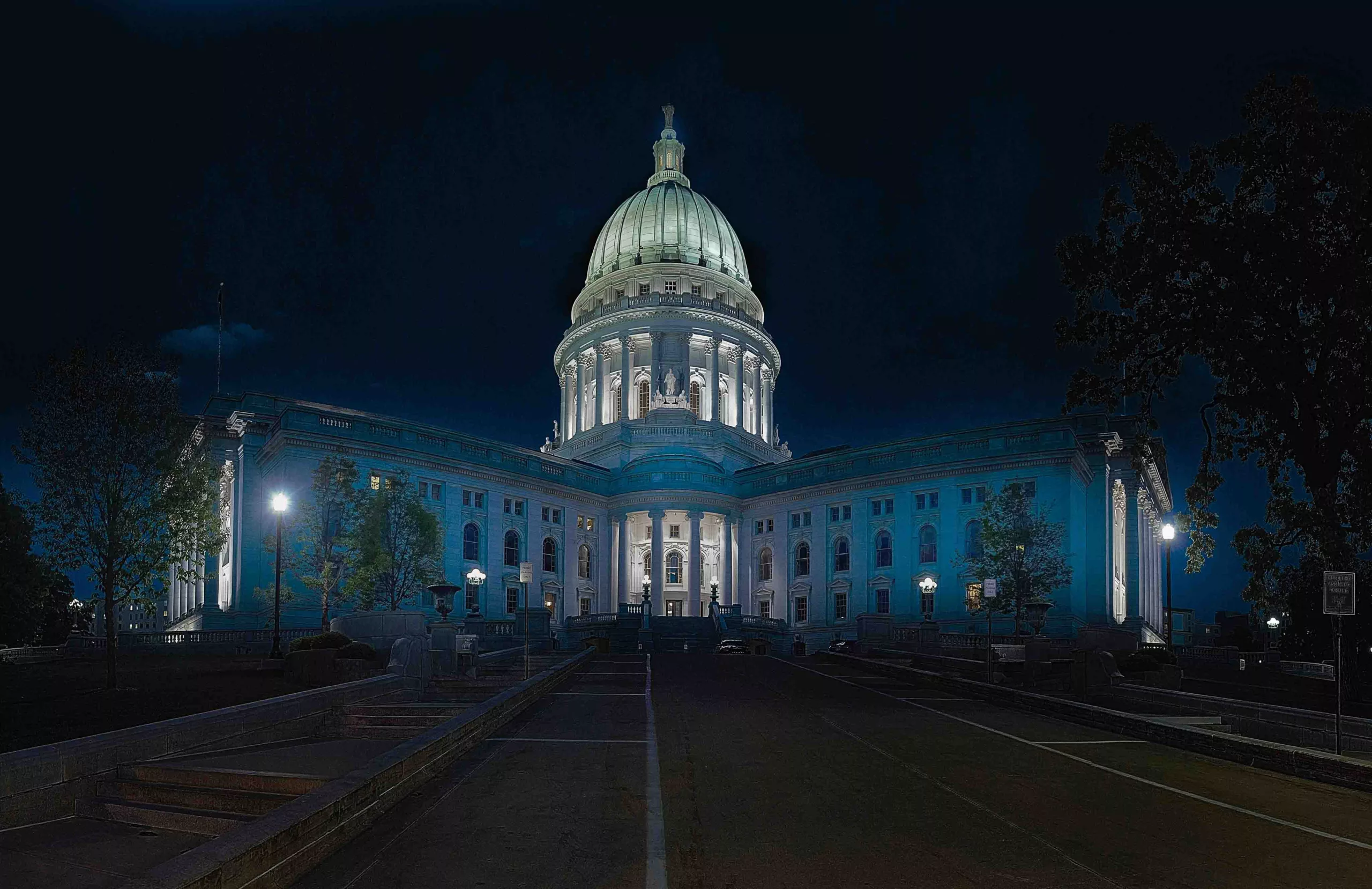 Illuminated capitol building at night with dome and front steps