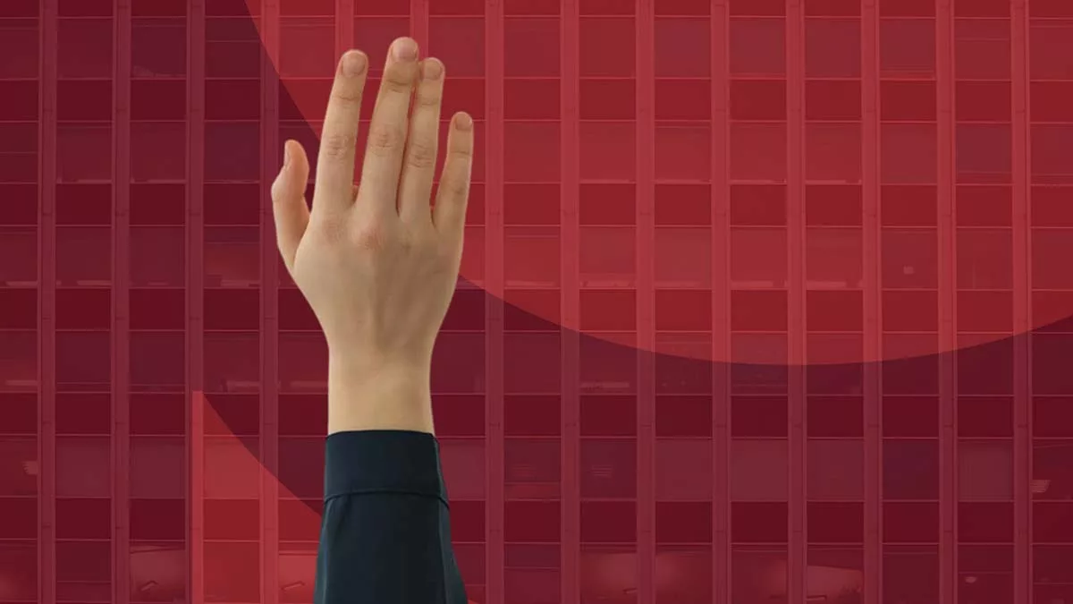 Raised hand in front of a red geometric pattern background