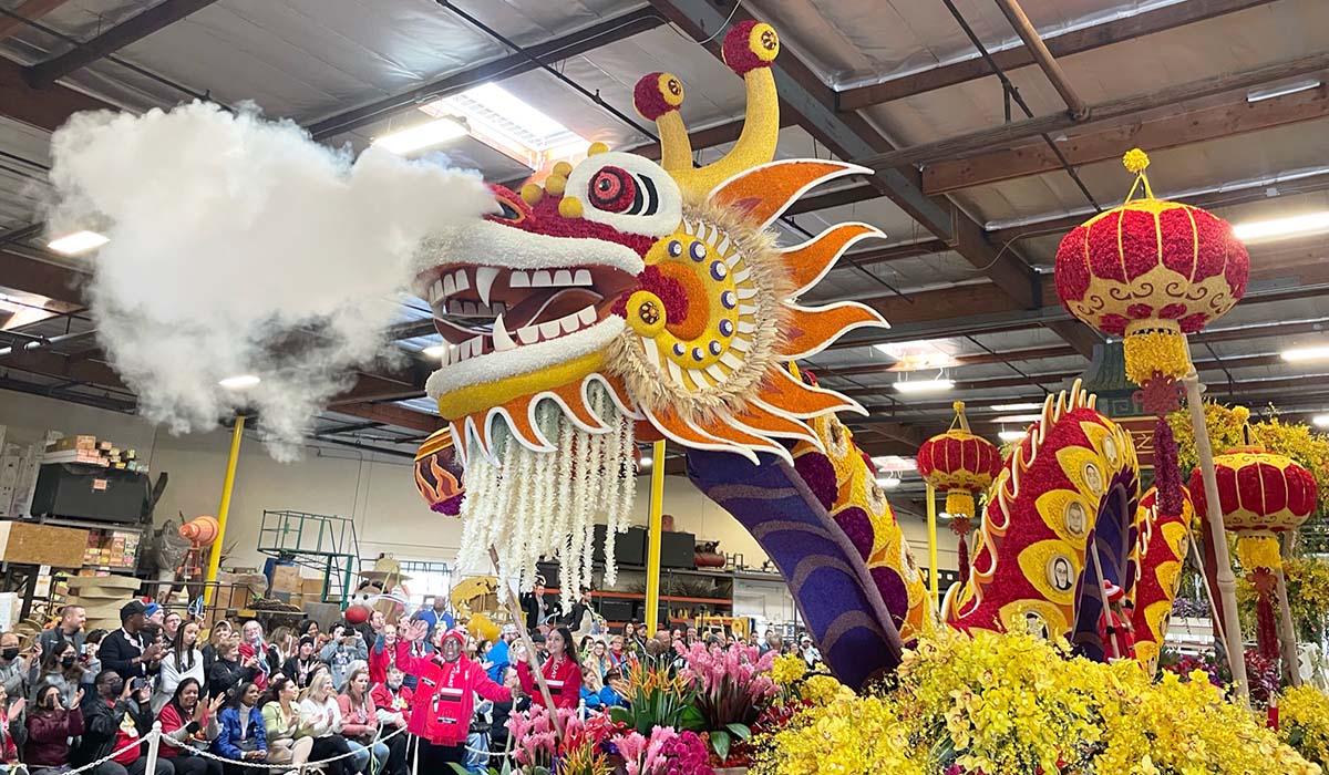Colorful dragon float with smoke effect at a festive parade event