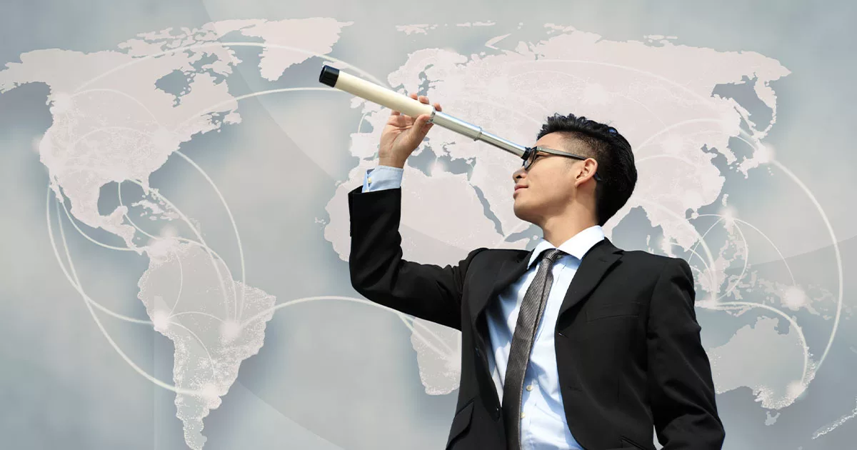 Businessman with telescope looking over world map background