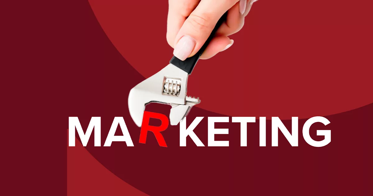 Hand tightening a wrench on the letter "E" in the word MARKETING on a red background