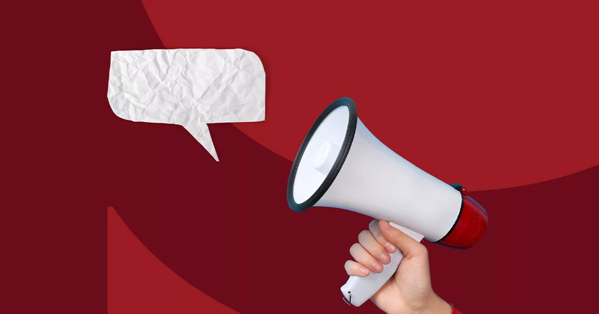 Hand holding megaphone with crumpled paper speech bubble on red background