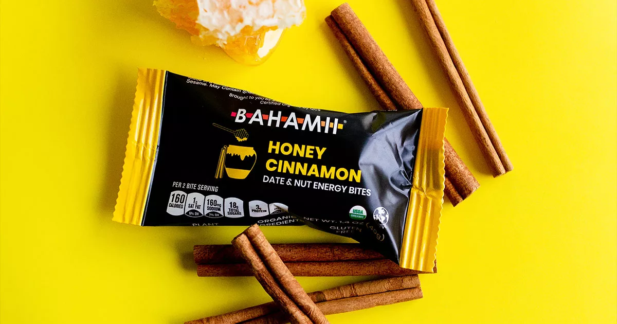 BAHAMII Honey Cinnamon energy bites packaging with cinnamon sticks on yellow background