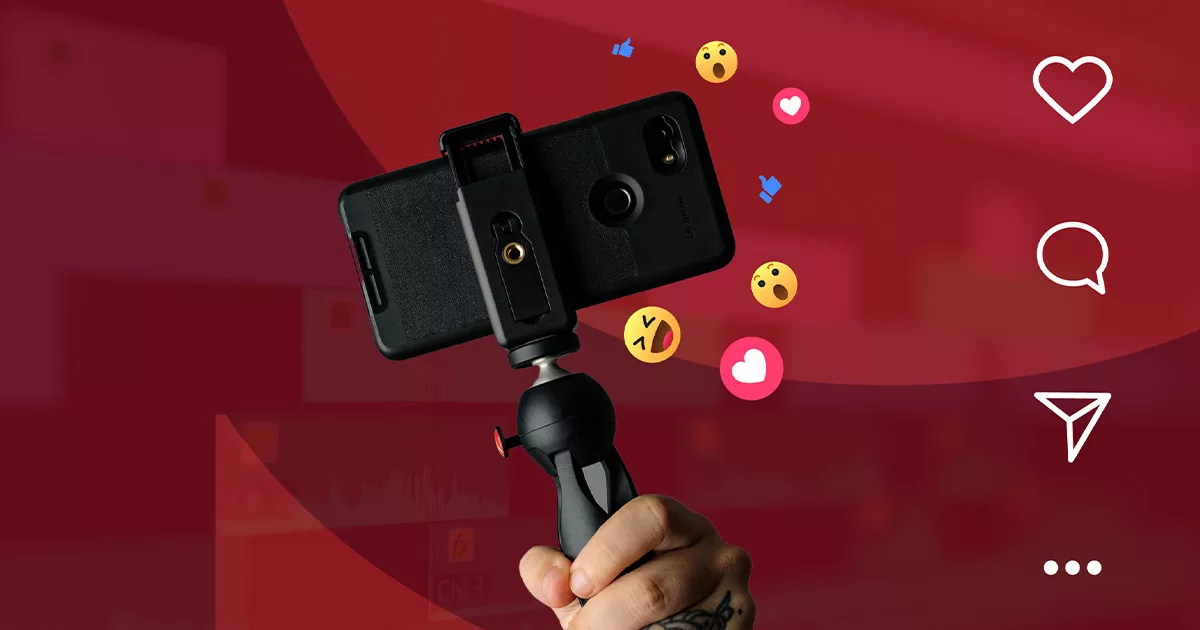 Hand holding smartphone on gimbal with social media reactions floating on red background