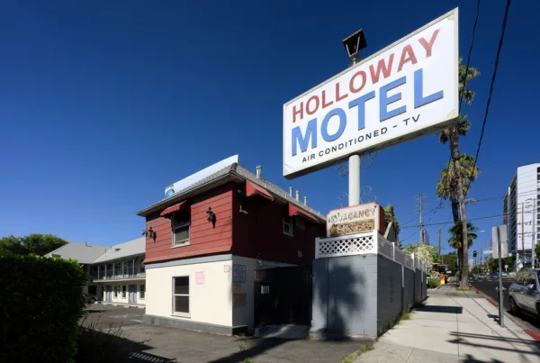 Vintage Holloway Motel sign above a red building on a sunny day with clear blue sky