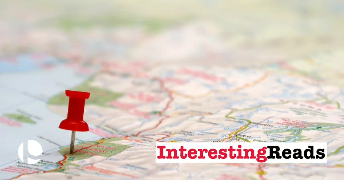 Red pushpin on map near text overlay "InterestingReads" for travel blog concept.