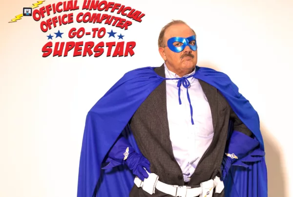 Man in superhero costume with text "Office Computer Go-To Superstar"