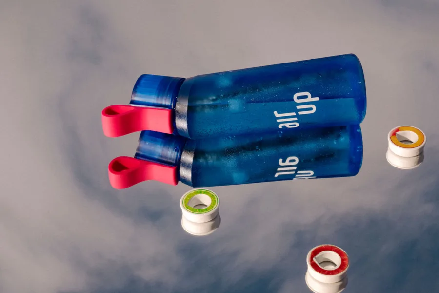 Blue water bottles with pink handles floating on a reflective surface