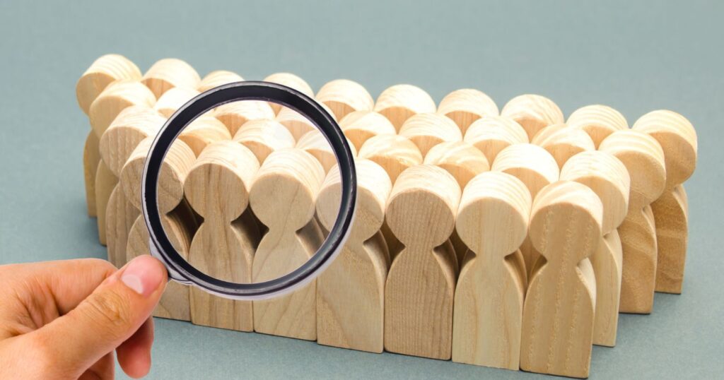Magnifying glass focusing on wooden human figures