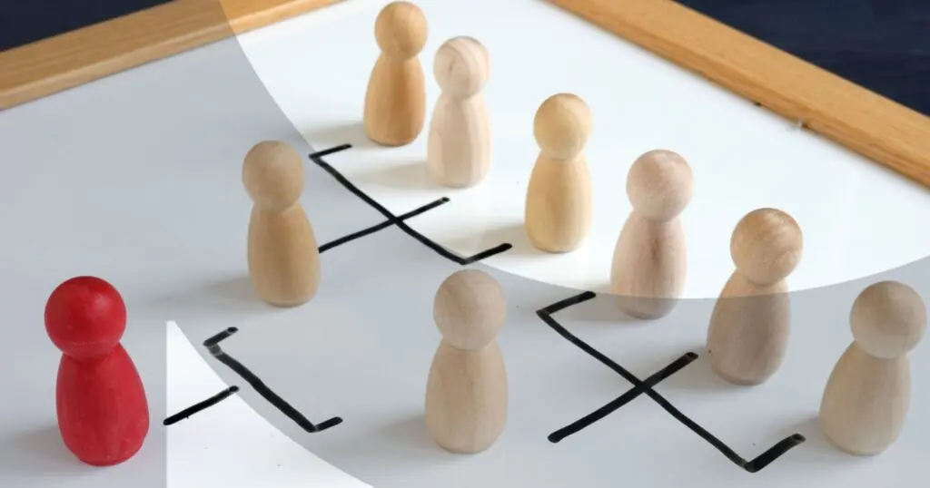 Red pawn facing wooden pawns on a whiteboard hierarchy chart.