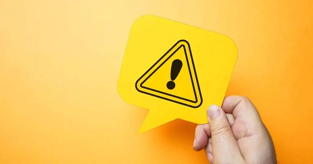 A hand holding a warning sign