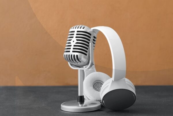 Headset leaning against microphone with brown background.