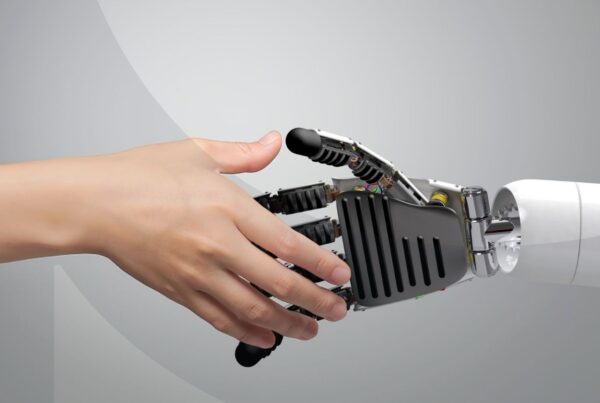 Human hand shaking a robot hand against a gray background
