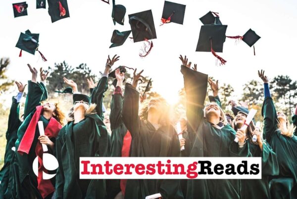 A group of college graduates throwing their hats in the air with the sun in the background
