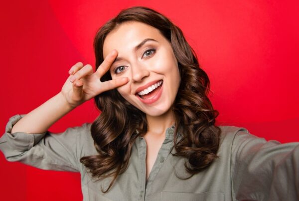 Woman taking a selfie with a red background.