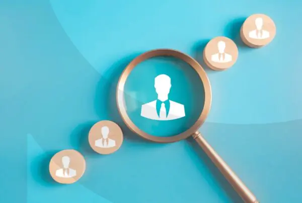 A magnifying glass hovering over an animated silhouette of a man, with two more silhouettes on either side.