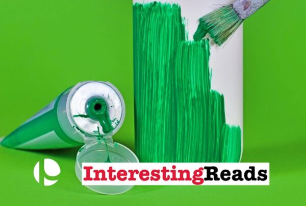 A tube of green paint laying next to a bottle that has been painted half green, all against a green background.